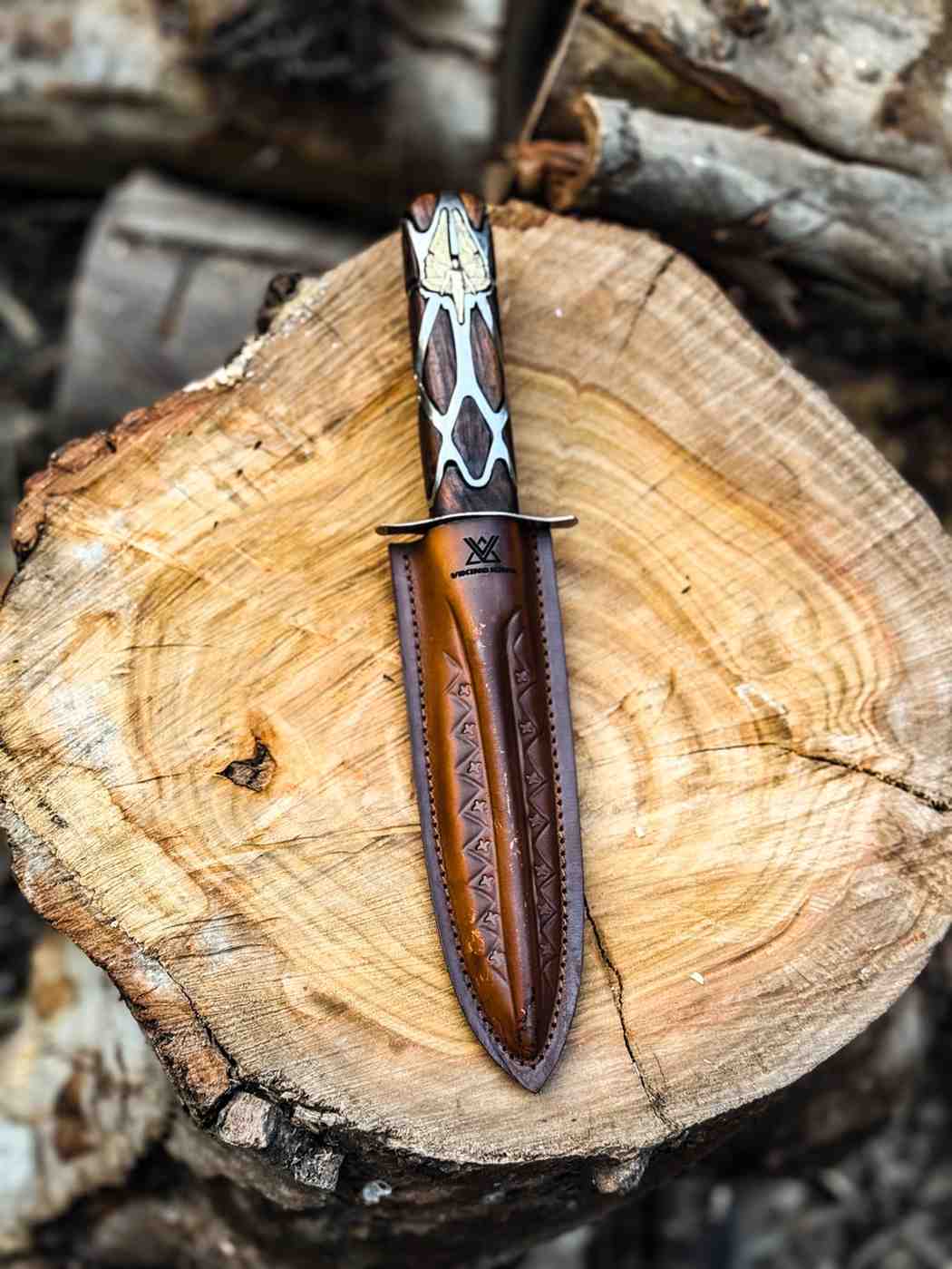 Top-down view of a handcrafted Subtle Knife cosplay prop with an artisan leather case on a natural wood surface, perfect for fantasy enthusiasts in the USA and UK.