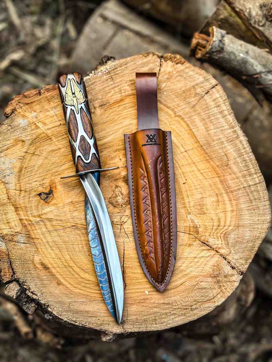 Fully optimized replica of The Subtle Knife from His Dark Materials with a detailed wooden and silver handle, resting next to its brown leather sheath on a wood log, handmade for fantasy cosplay fans in the USA.