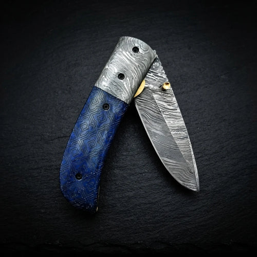 Alien graphic folding knife — laser engraving detail on blue camel bone