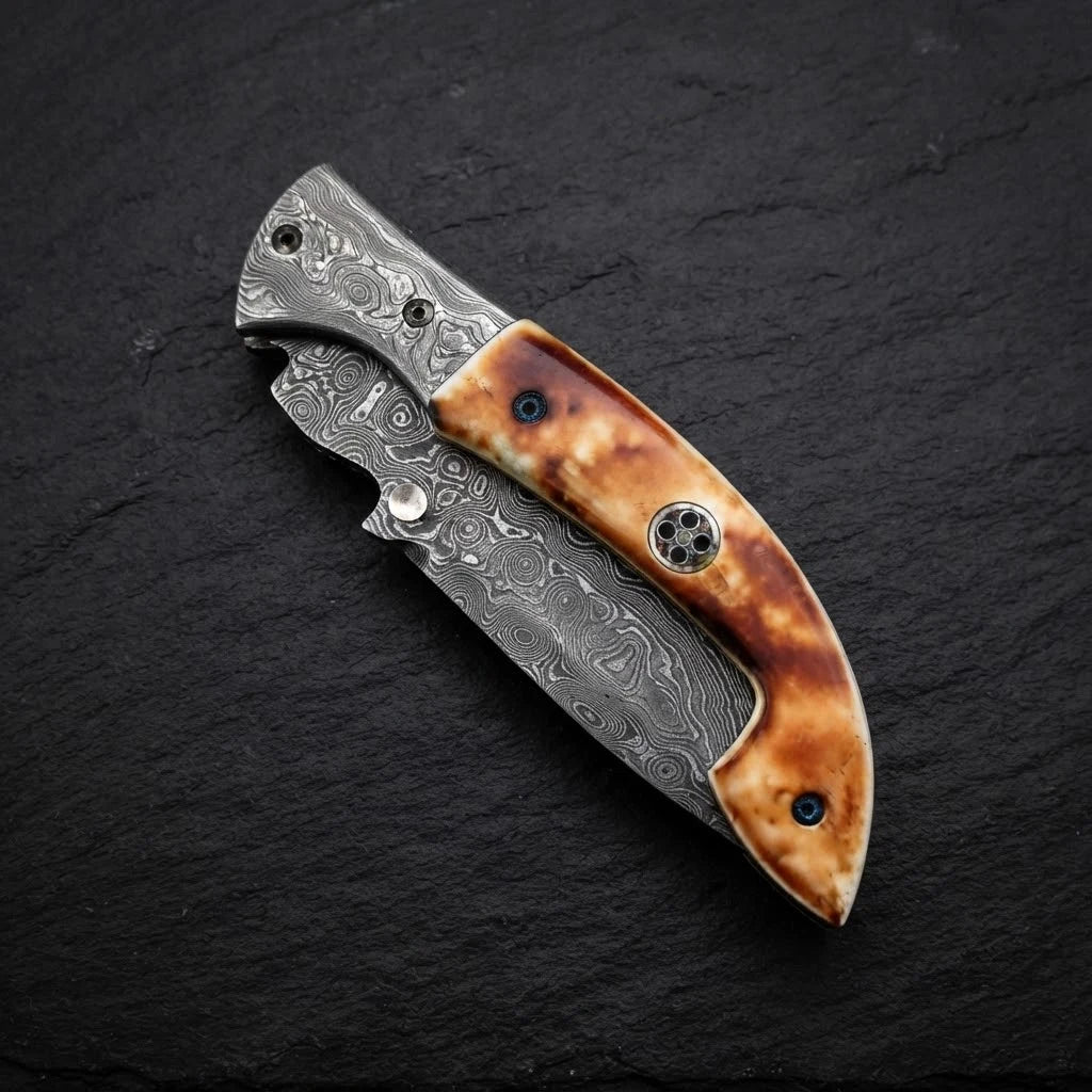 Burnt camel bone folding pocket knife — Damascus rain drop pattern blade close-up