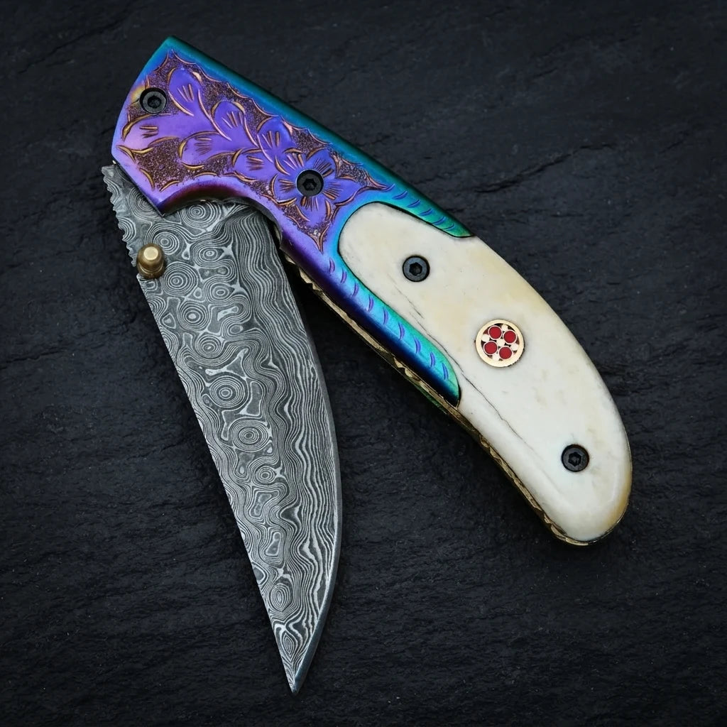 Damascus drop point folding knife — hand-engraved oxidized bolster and mosaic pin close-up