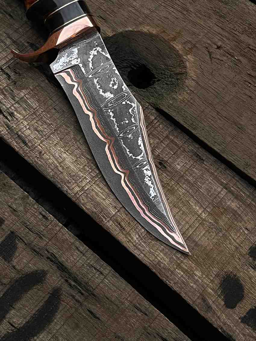 Detailed close-up of a hand-forged Copper Damascus steel Bowie knife blade showing unique layered patterns