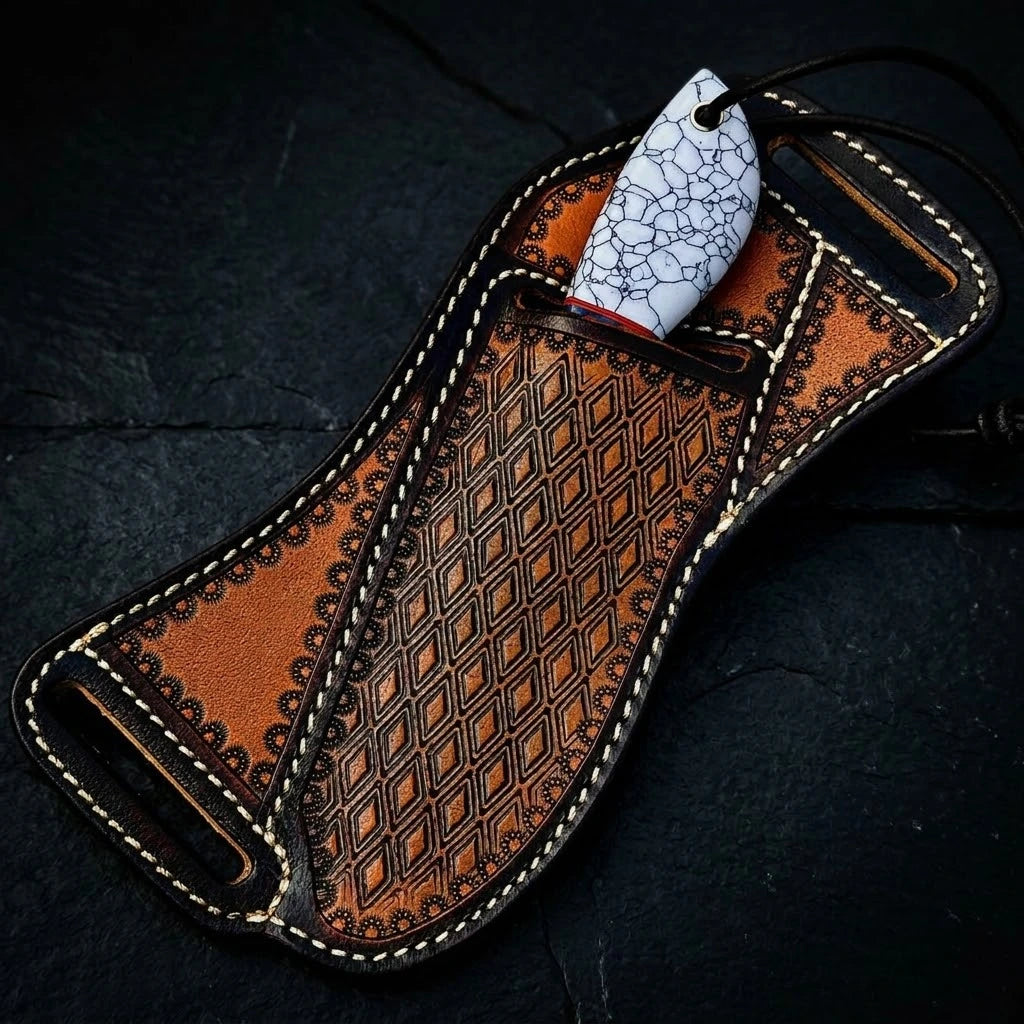 A custom hunting knife tucked securely inside its heavily tooled brown leather belt sheath, showing only the white cracked-pattern handle against a dark slate background.