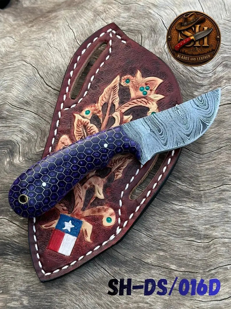 Resin and steel handle of a Damascus cowboy skinner knife