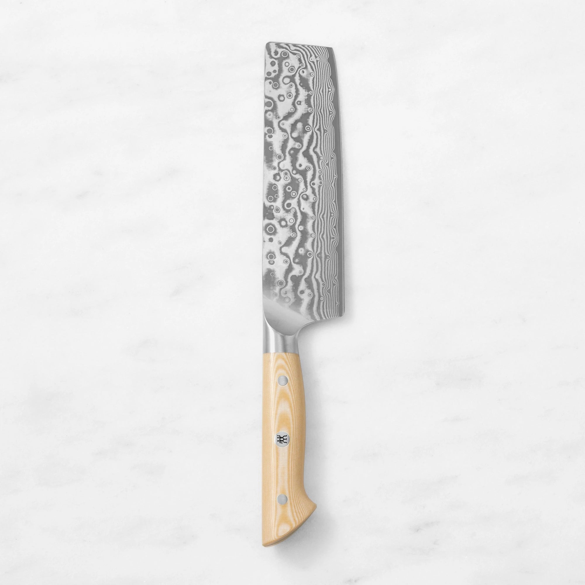 Damascus steel Nakiri vegetable cleaver with a light wood handle and mosaic pin, centered vertically against a smooth white marble background.