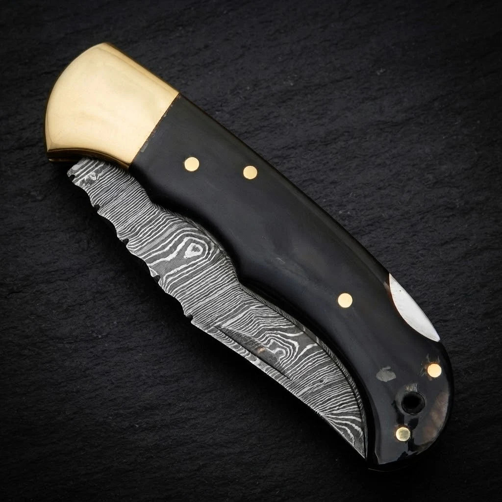 Damascus EDC folding knife with buffalo horn handle and brass bolster – blade close-up