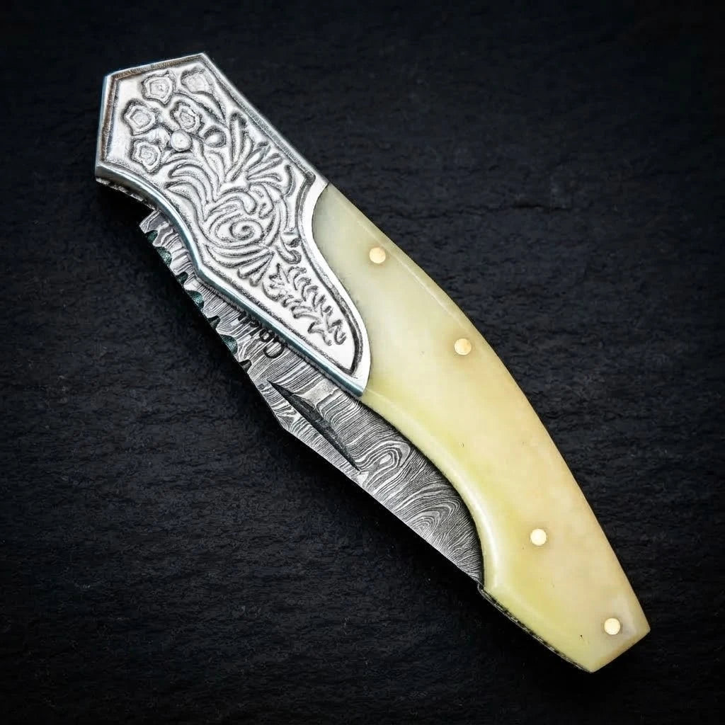 Damascus EDC folding knife with camel bone handle and engraved bolster – blade close-up