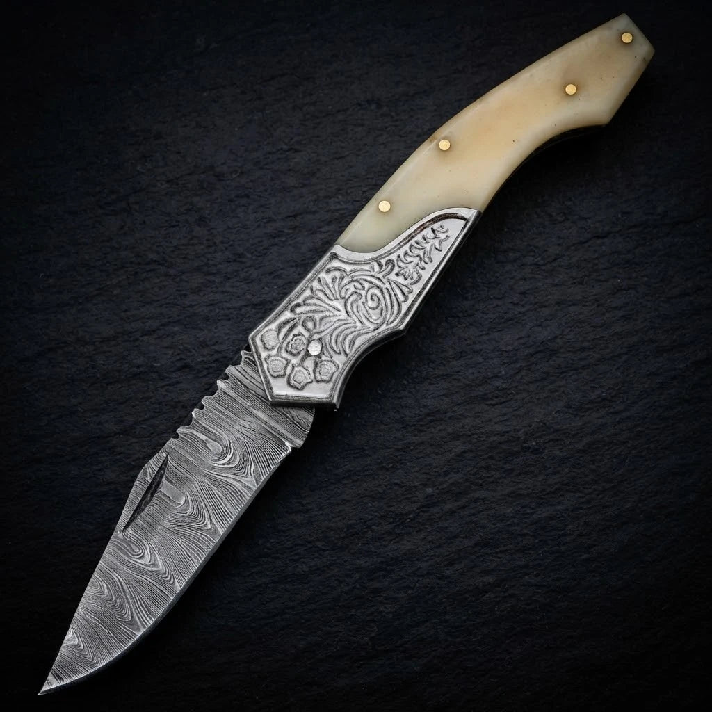 Damascus EDC folding knife with camel bone handle and engraved bolster – folded with sheath