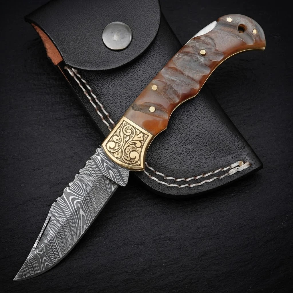 Damascus EDC folding knife with ram horn handle and brass bolster – blade close-up