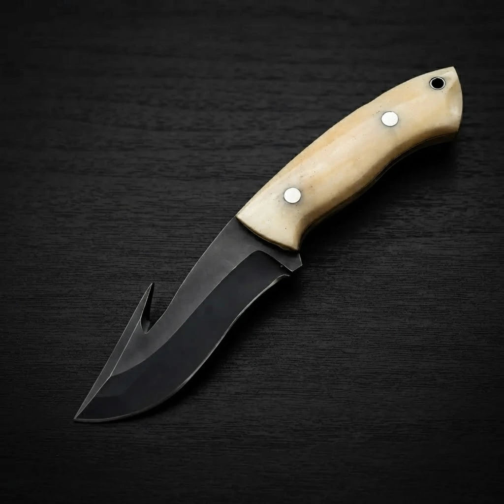 Handmade gut hook cowboy knife featuring a dark forged rasp steel blade and smooth camel bone handle scales, displayed on a black wood background