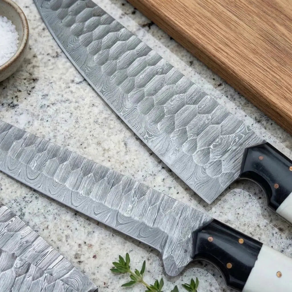 Close-up of hammered Damascus steel blade pattern on a handmade chef knife set