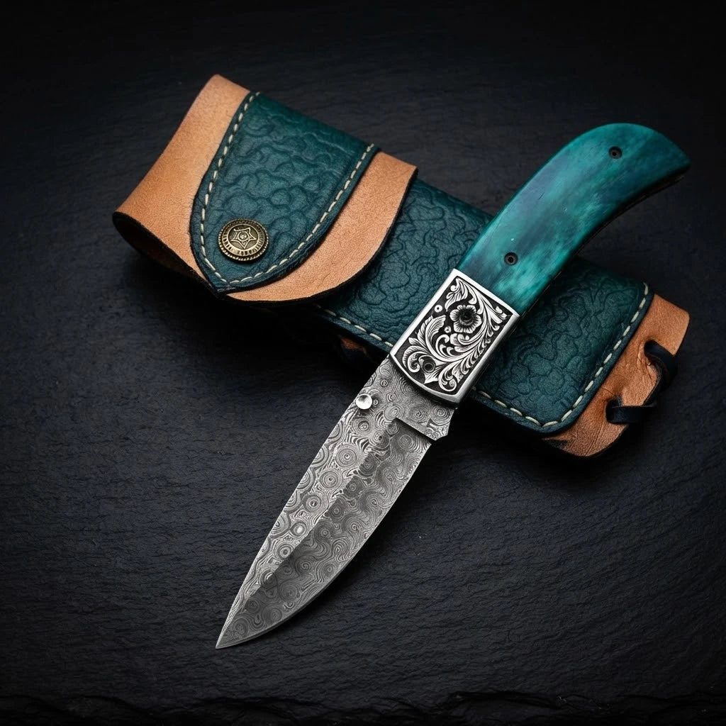 Damascus folding knife with green camel bone handle and steel bolster – blade close-up