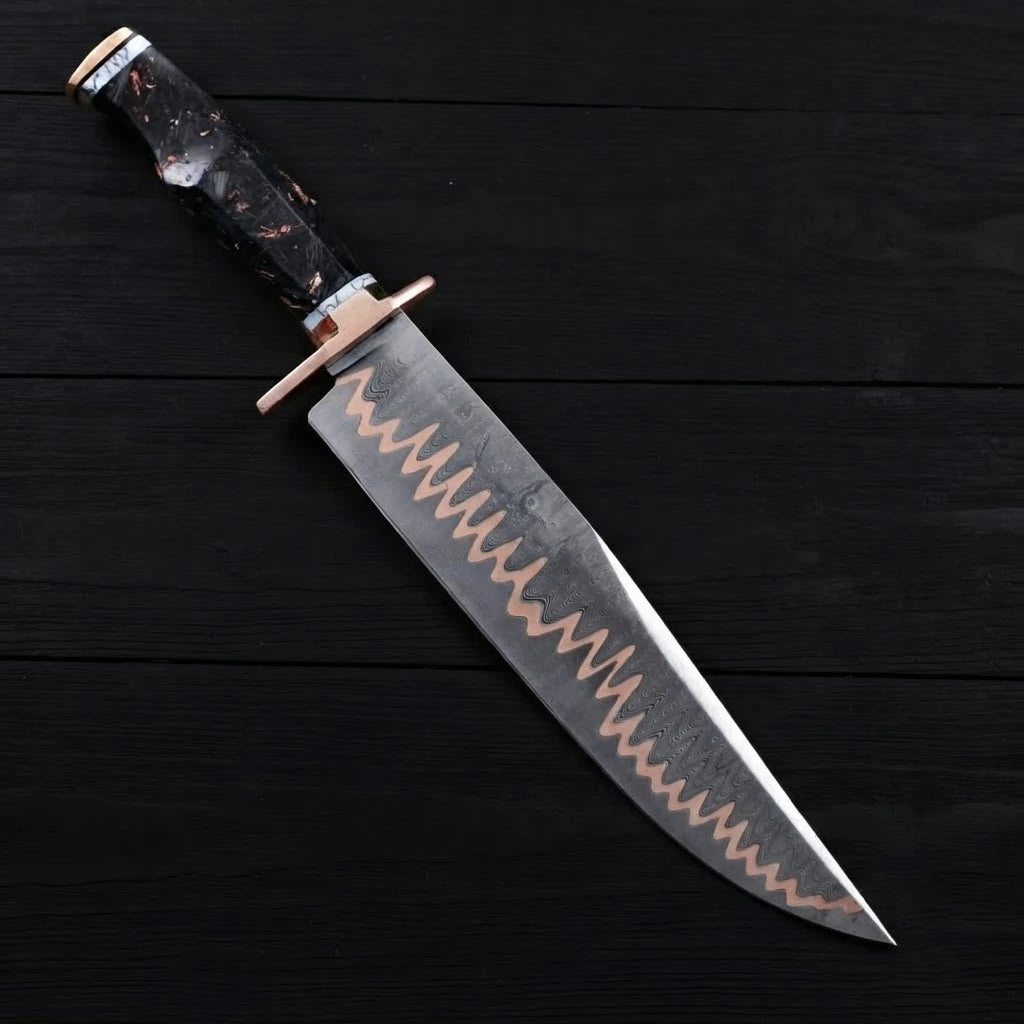 A full diagonal view of an 11-inch Copper Damascus Bowie knife with a straight copper guard and marbled black resin handle on a dark wood background