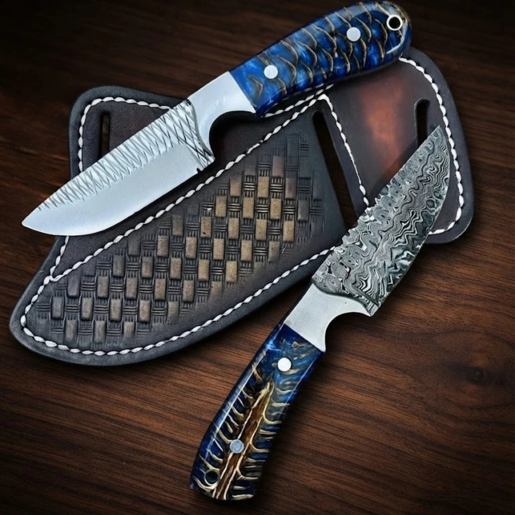 A matching custom handmade knife set featuring one rasp steel blade with textured cross-hatch filework and one patterned Damascus steel blade, both styled with polished metal bolsters and vibrant blue-dyed pine cone hybrid resin handles, displayed over a basket-weave tooled brown leather double pancake sheath on a dark wood background