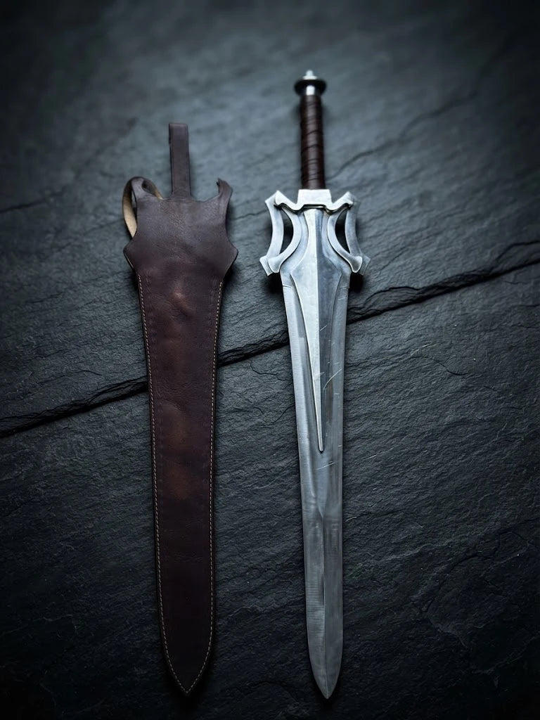 Handmade He-Man Power Sword replica displayed alongside its matching brown custom leather sheath on a dark slate background