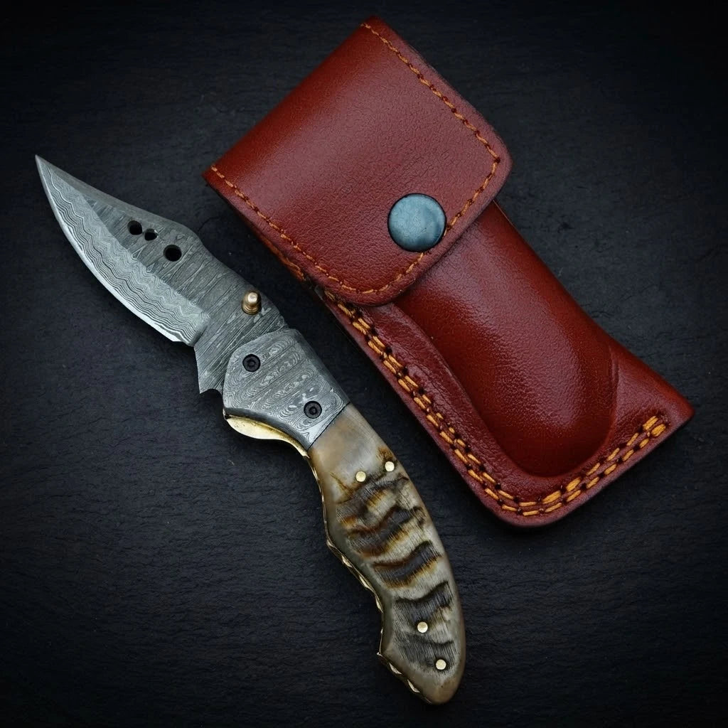 Damascus folding knife — ram horn handle and bolster detail