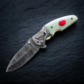 Damascus folding knife with red stone inlay camel bone handle