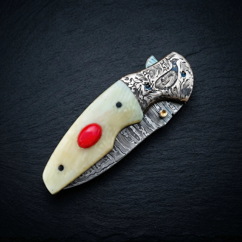 Close-up of camel bone handle with red stone inlay on Damascus knife