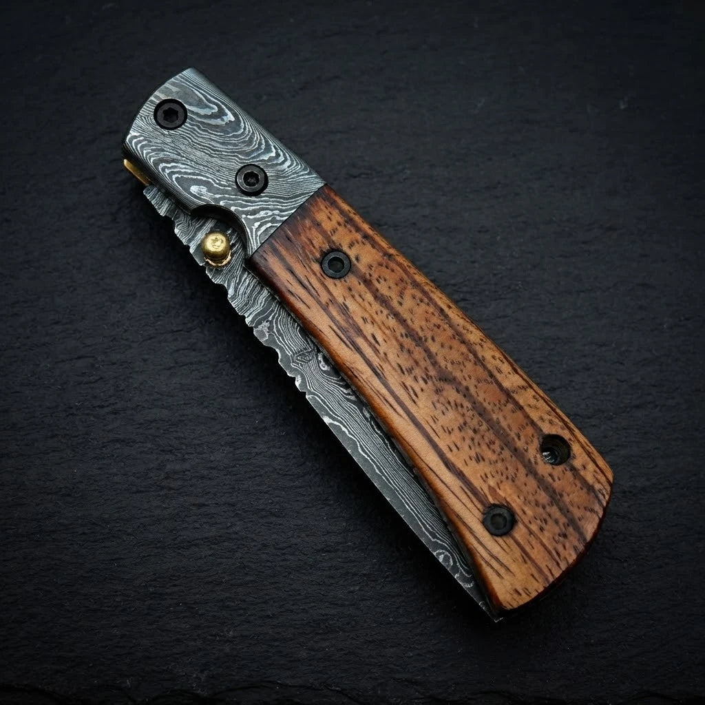 Damascus folding knife — rosewood handle and Damascus bolster close-up