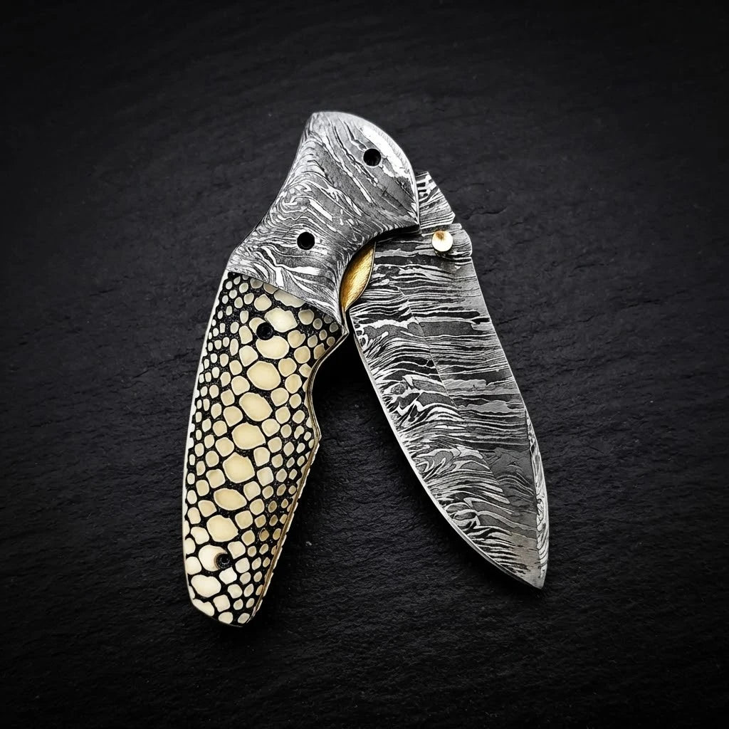 Scrimshaw camel bone folding pocket knife — Damascus steel blade close-up