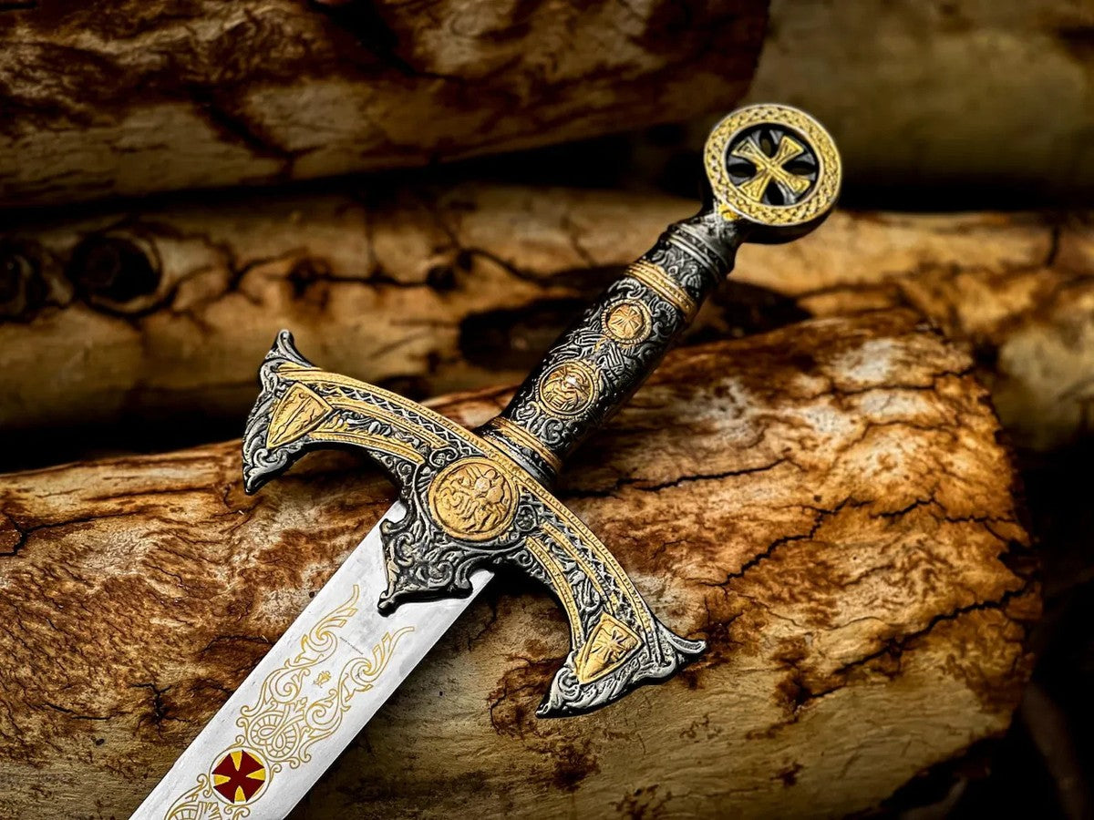 Handcrafted Templar Knight sword with brown leather sheath, featuring gold-plated ornate hilt and historical cross engraving, presented on a dark rustic wooden background