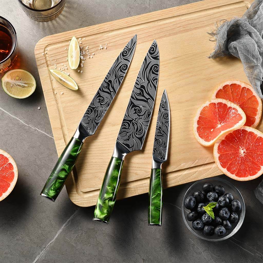 Damascus-pattern blades of the Tengoku 8-piece chef knife set with green resin handles