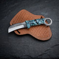 Handmade hawkbill knife with teal marble resin handle and toothed ring pommel