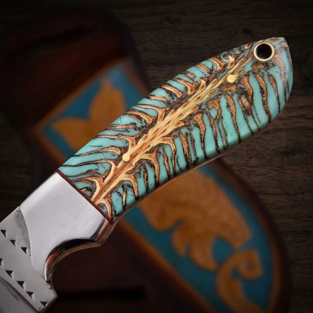 A macro close-up of a custom cowboy knife handle made from a turquoise-dyed pine cone hybrid resin scale, showing two brass pins and a lanyard hole, attached to a polished metal bolster with a blurred tooled leather sheath in the background.
