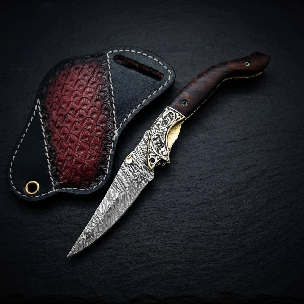 Damascus folding knife with walnut wood handle and engraved brass bolster – blade close-up