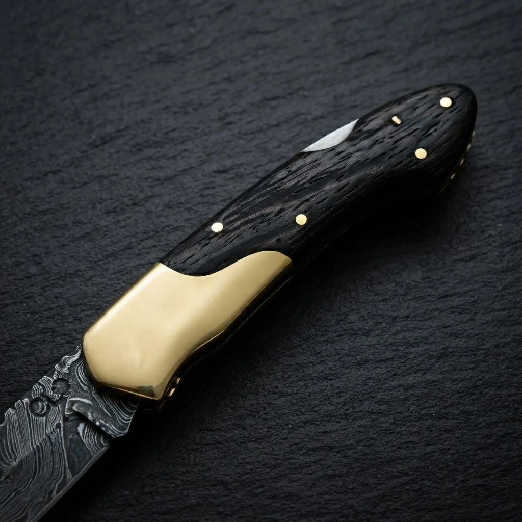 Damascus folding knife — wenge wood handle and brass bolster close-up